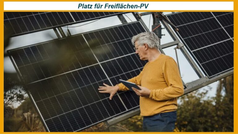 Ein Fachmann prüft eine Photovoltaikanlage auf einer Freifläche