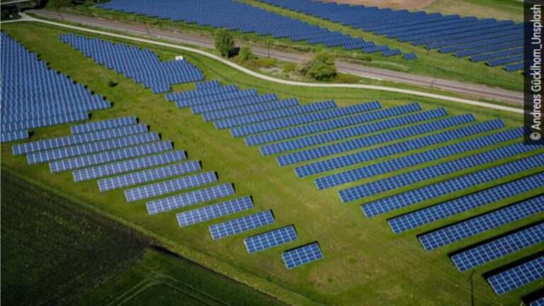 Ein Solarpark mit mehreren Solarpaneelen, der durch bürgerschaftliches Engagement zur Förderung erneuerbarer Energien entstanden ist.