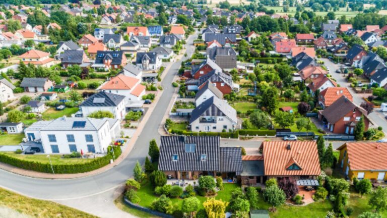 Stadtansicht mit zahlreichen Dächern, die mit Solaranlagen ausgestattet sind.