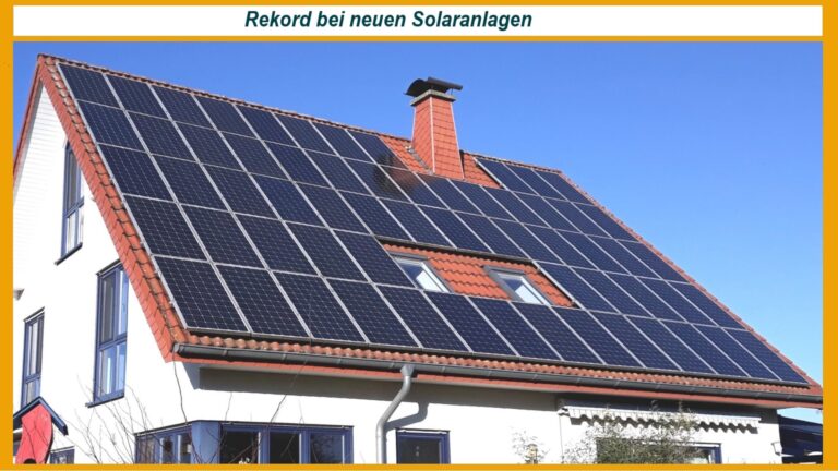 Eine neu montierte Solaranlage auf einem Dach unter blauem Himmel.