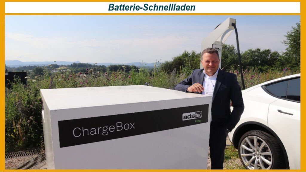 Thomas Speidel steht vor einer ChargeBox, einem batteriegepufferten Hochleistungssystem zum schnellen Laden von Elektrofahrzeugen.