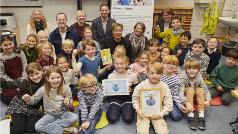 Gruppenfoto mit Ministerin Mona Neubaur bei der Urkundenübergabe an die Don-Bosco-Grundschule Düsseldorf.