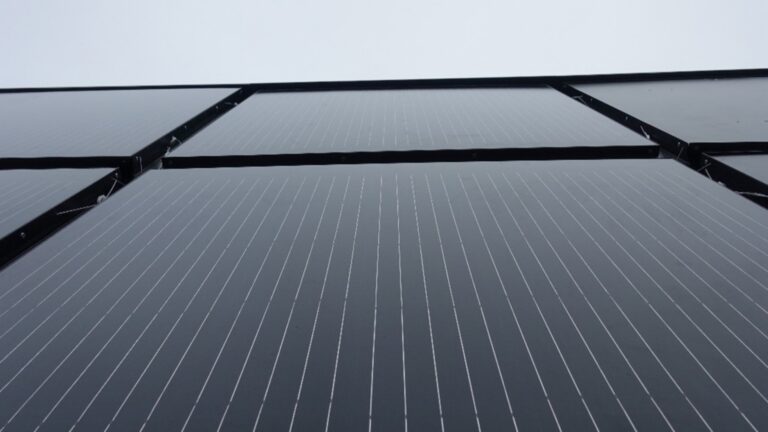 Großaufnahme eines wärmegedämmten BIPV-Fassadenelements mit integrierter Photovoltaik für nachhaltige Gebäudesanierung.