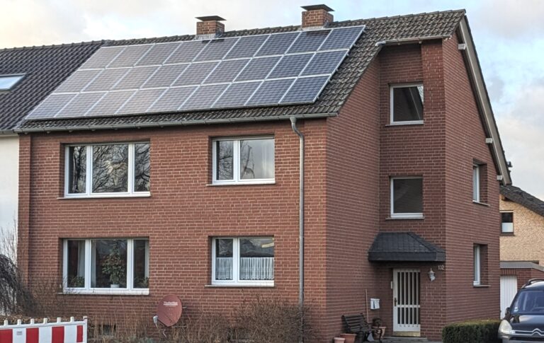 Mehrfamilienhaus mit Solaranlage auf dem Dach, ein Symbol für die Energiewende und nachhaltige Energiespeicherung.