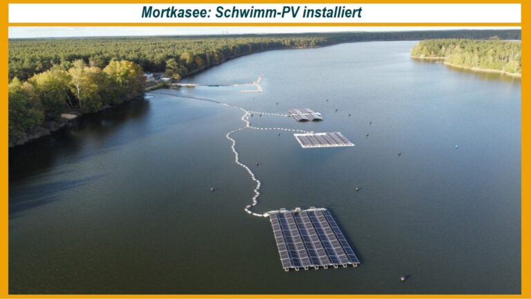 Luftaufnahme eines Sees mit schwimmenden Photovoltaikanlagen, die im Rahmen eines Forschungsprojekts installiert wurden.