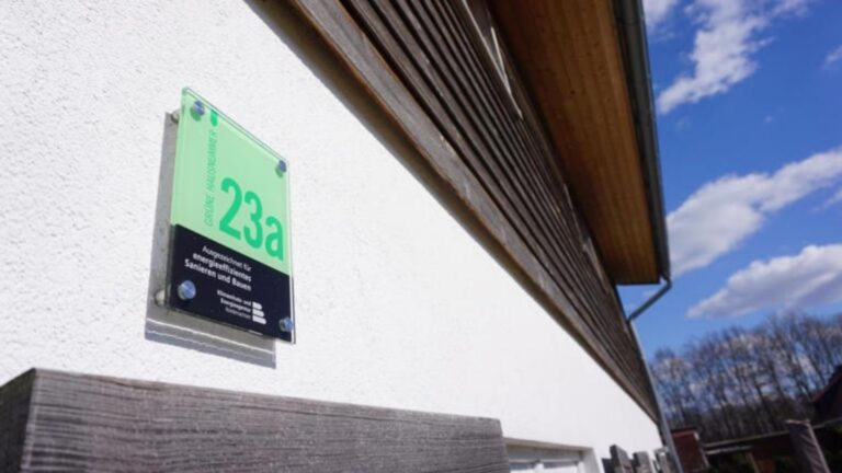 Eine Grüne Hausnummer an einer Gebäudewand – Symbol für nachhaltiges Bauen, Photovoltaik und Energieeffizienz.