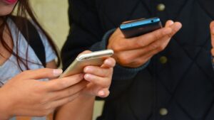 Zwei Hände, die Smartphones halten, um den Link zu PV Navi auf LinkedIn und Instagram zu teilen. Eine symbolische Darstellung der Beteiligung an der Energiewende durch digitale Vernetzung.