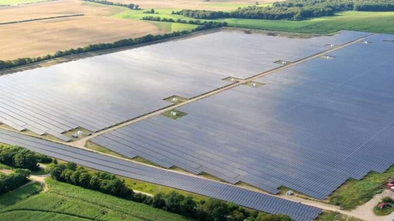 Solaranlage in einem Solarpark mit zahlreichen Solarmodulen, die auf einem offenen Feld installiert sind, zur Stromerzeugung aus erneuerbaren Energien.
