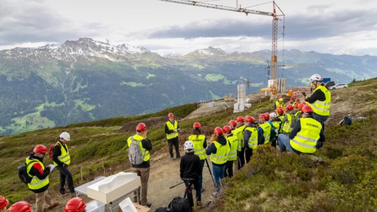 Michael Roth präsentiert das alpine Solarkraftwerk Madrisa Solar vor Baustelle in den Bergen