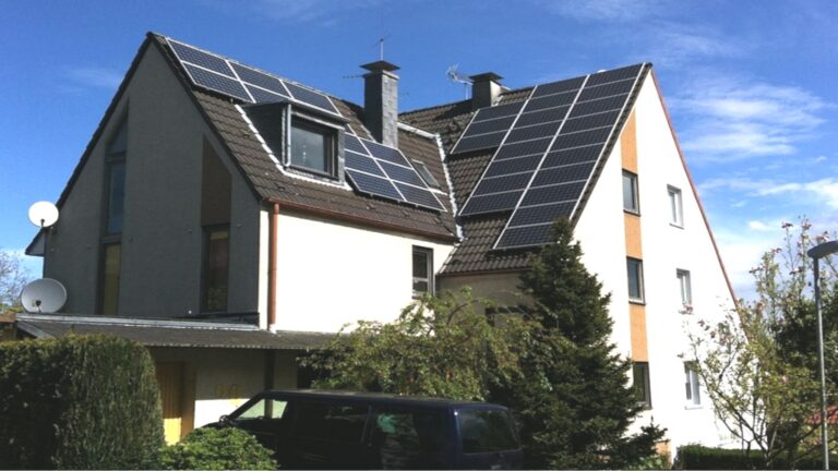 Eigenheim mit Photovoltaik-Anlage auf dem Dach, Symbol für Energiewende und solare Eigenstromerzeugung.