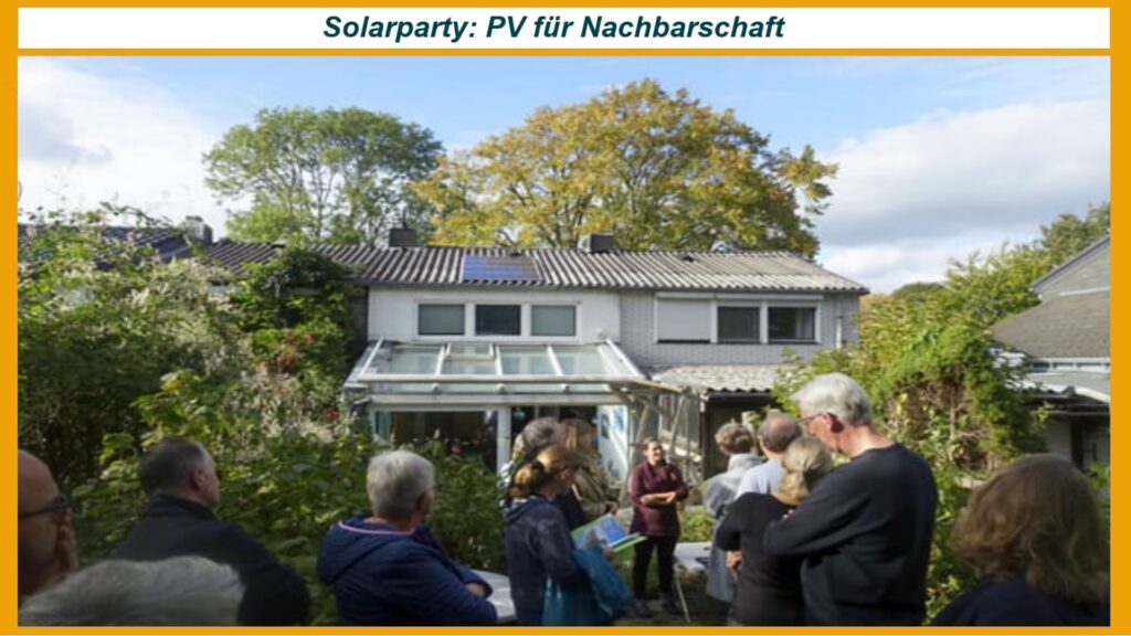 Teilnehmende einer Solarparty blicken auf ein mit Photovoltaik-Modulen ausgestattetes Haus in der Nachbarschaft.