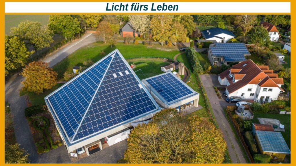 Draufsicht auf eine Kirche mit Photovoltaik-Paneelen auf dem Dach, die erneuerbare Energie erzeugen.