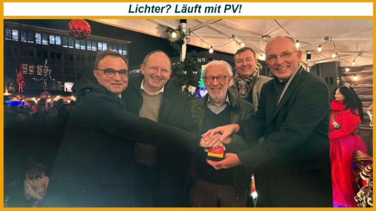 Fünf Personen schalten gemeinsam die solarbetriebene Weihnachtsbeleuchtung in Mannheim ein, im festlichen Außenbereich.