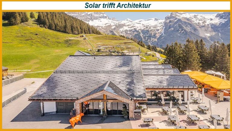 Alpines Gebäude mit großflächigem Solardach, Terrasse mit Tischen und gelben Sonnenschirmen und orangefarbener Kuhstatue am Eingang.