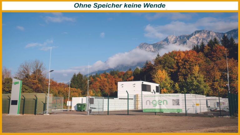 Eingezäunte n-gen Energiespeicher-Anlage vor herbstlichen Bäumen und Bergen, Schriftzug oben: Ohne Speicher keine Wende